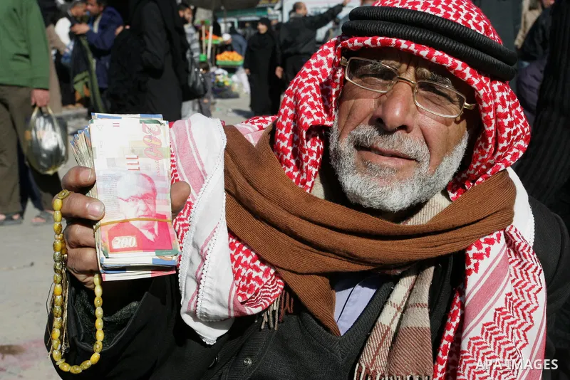 A Palestinian man exchanges shekels for dollars in Rafah refugee camp in the southern Gaza Strip on December 31, 2011.Photo by Abed Rahim Khatib
