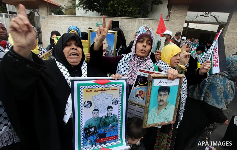 Palestinians women hold pictures of their prison relatives in Israeli jails as they gather in a weekly activity calling for their liberty at the Red Cross headquarters in Gaza City on Jan 02, 2012. About 7000 prisoners a...