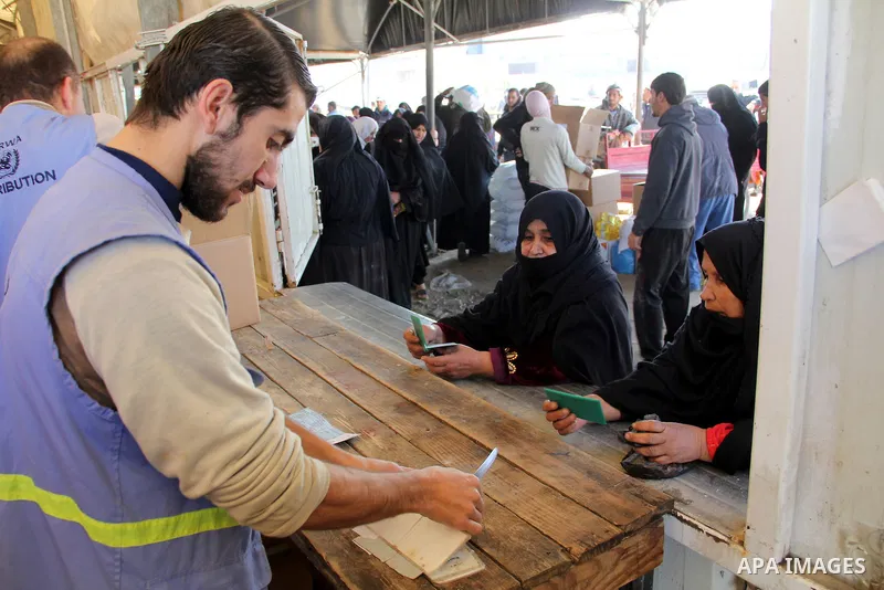 Palestinians collect food aid from the United Nations Relief and Works Agency (UNRWA) in the Rafah refugee camp, southern Gaza Strip, on Jan 04, 2012. Photo by Hatem Omar