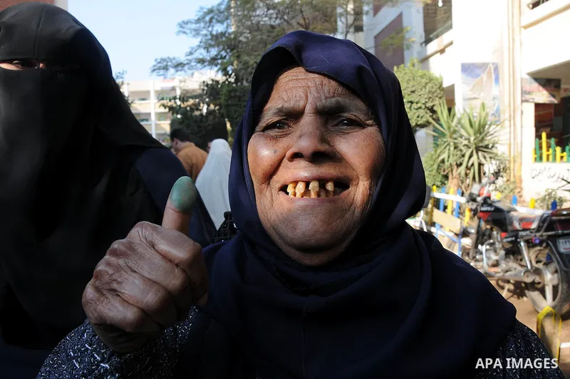 An Egyptian woman shows her ink marked finger after casting her vote during the second day of the third round of the elections for Egypt's parliament, in Egypt, Wednesday, Jan. 4, 2012. Egyptians are voting in the final...