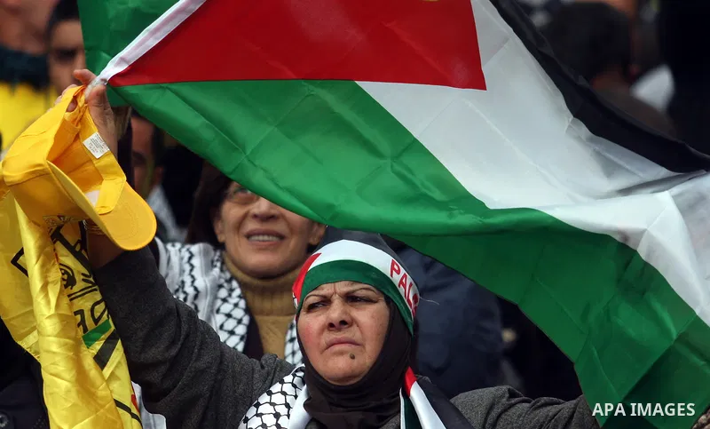 A Palestinian woman take part during a celebration to mark the 47th anniversary of the Fatah political movement, in the West Bank city of Ramallah, Wednesday, Jan. 4, 2012. Photo by Issam Rimawi