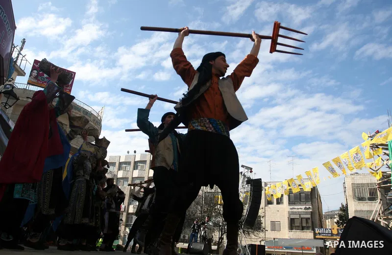 A Palestinians take part during a celebration to mark the 47th anniversary of the Fatah political movement, in the West Bank city of Ramallah, Wednesday, Jan. 4, 2012. Photo by Issam Rimawi