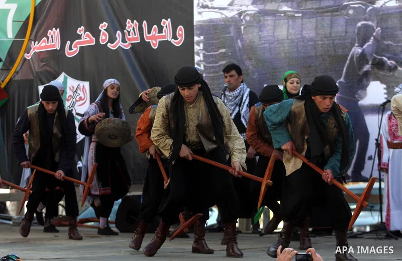 A Palestinians take part during a celebration to mark the 47th anniversary of the Fatah political movement, in the West Bank city of Ramallah, Wednesday, Jan. 4, 2012. Photo by Issam Rimawi