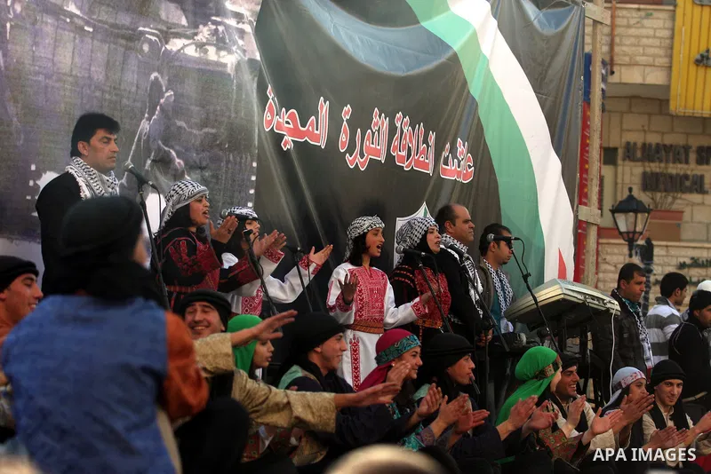 A Palestinians take part during a celebration to mark the 47th anniversary of the Fatah political movement, in the West Bank city of Ramallah, Wednesday, Jan. 4, 2012. Photo by Issam Rimawi