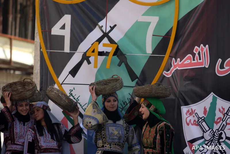 A Palestinians take part during a celebration to mark the 47th anniversary of the Fatah political movement, in the West Bank city of Ramallah, Wednesday, Jan. 4, 2012. Photo by Issam Rimawi