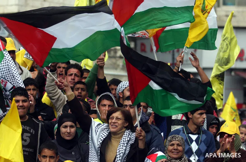 Palestinians hold up Palestinian flags and yellow Fatah flags during a celebration to mark the 47th anniversary of the Fatah political movement, in the West Bank city of Ramallah, Wednesday, Jan. 4, 2012. Photo by Issam...