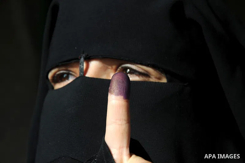 A veiled Egyptian woman shows her ink-stained finger after voting outside a polling station in Qaliubia, some 40 kms north of Cairo, on January 4, 2012 as Egyptians headed to the polls again in the final round of a phase...