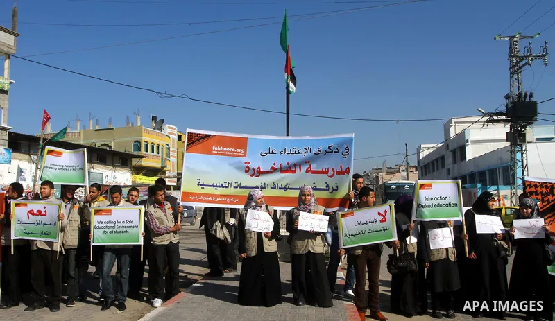 Palestinian youths hold pictures and banners during a protest in front of the Al-fakhura school against the Israeli violations of the educational institutions in the Gaza Strip, in Gaza City, on 05, 2012. Photo by Ashraf...