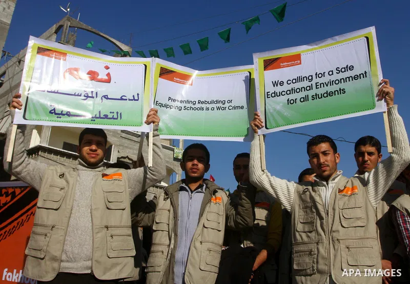 Palestinian youths hold pictures and banners during a protest in front of the Al-fakhura school against the Israeli violations of the educational institutions in the Gaza Strip, in Gaza City, on 05, 2012. Photo by Ashraf...