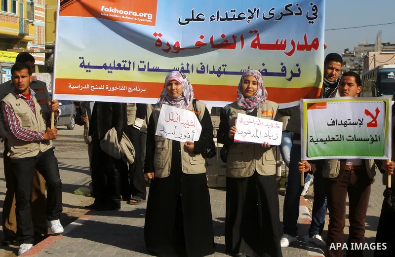 Palestinian youths hold pictures and banners during a protest in front of the Al-fakhura school against the Israeli violations of the educational institutions in the Gaza Strip, in Gaza City, on 05, 2012. Photo by Ashraf...