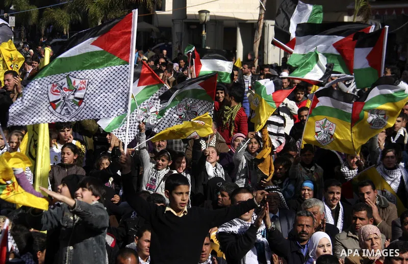 Supporters of the Fatah wave flags as they join in celebrations on the occasion of the 47th anniversary of the founding of the Fatah movement in the West Bank City of Nablus, 05 January 2012. The Fatah Movement, which no...