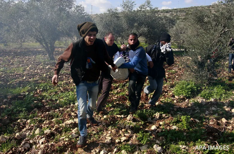 Palestinian protesters help a wounded boy during a protest against the expansion of the nearby Jewish settlement of Halamish in the West Bank village of Kafer qadum, near Nablus, Friday, Jan. 6, 2012. Photo by Wagdi Esht...