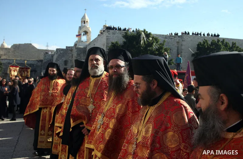 Greek Orthodox clergy lining up in Manger Square as the Christmas eve procession gets underway in the West Bank town of Bethlehem, 06 January 2012. Behind is the Church of the Nativity, traditionally accepted by all Chri...
