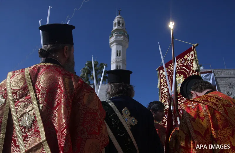 Greek Orthodox clergy lining up in Manger Square as the Christmas eve procession gets underway in the West Bank town of Bethlehem, 06 January 2012. Behind is the Church of the Nativity, traditionally accepted by all Chri...