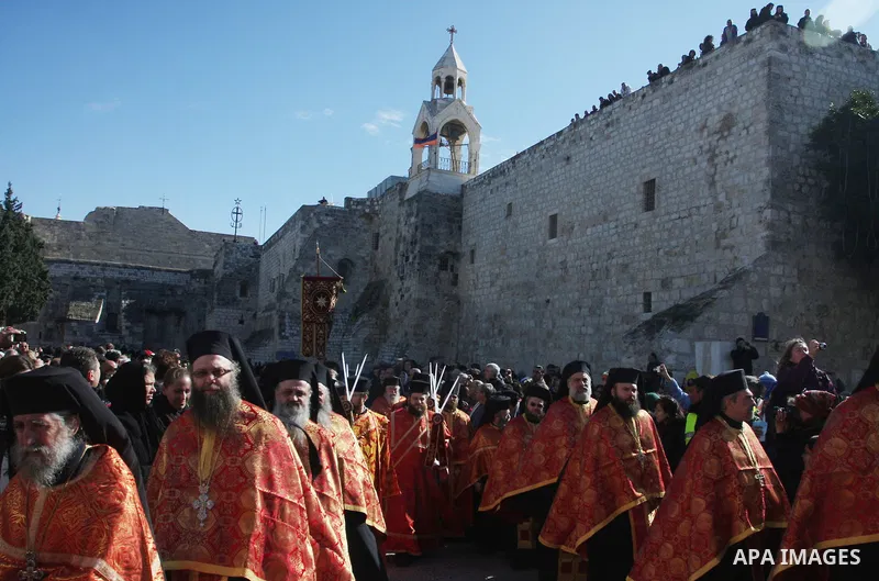 Greek Orthodox clergy lining up in Manger Square as the Christmas eve procession gets underway in the West Bank town of Bethlehem, 06 January 2012. Behind is the Church of the Nativity, traditionally accepted by all Chri...