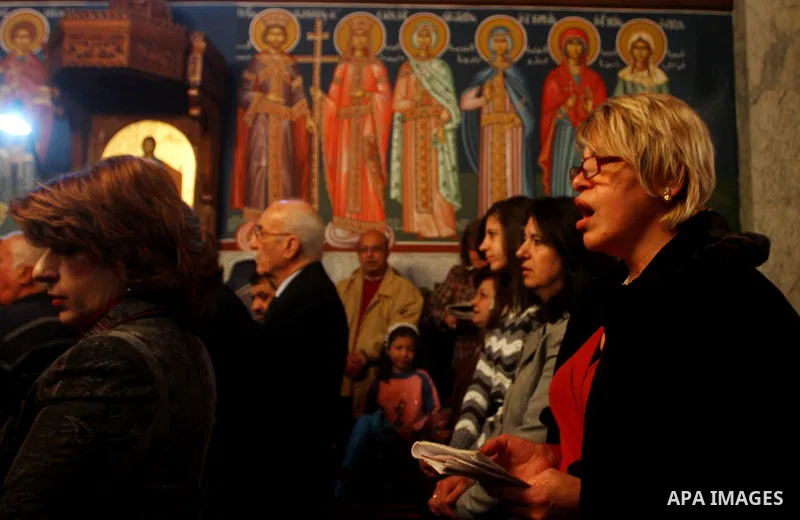 Palestinian Greek Orthodox Christians attend Christmas mass at the Orthodox Saint Porfirios church in Gaza City on January 7, 2012. The Orthodox Church celebrates Christmas and other religious holidays according to the J...