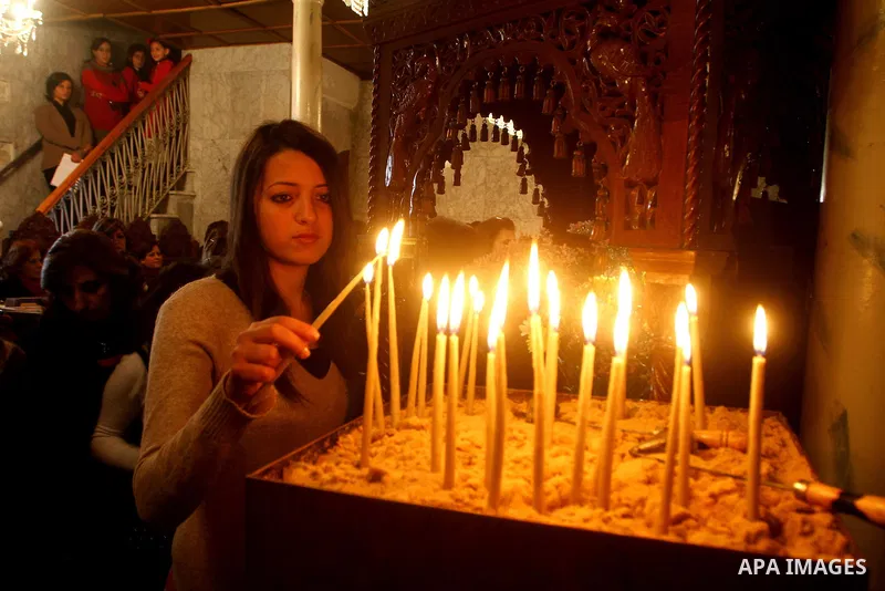 Palestinian Greek Orthodox Christians attend Christmas mass at the Orthodox Saint Porfirios church in Gaza City on January 7, 2012. The Orthodox Church celebrates Christmas and other religious holidays according to the J...