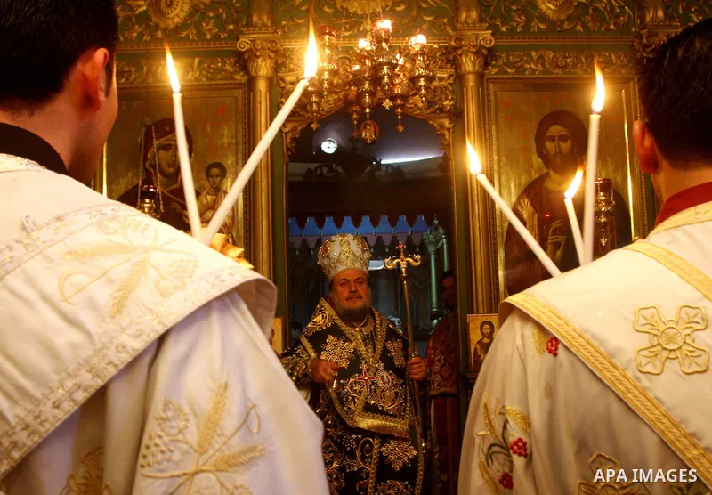 Palestinian Greek Orthodox Christians attend Christmas mass at the Orthodox Saint Porfirios church in Gaza City on January 7, 2012. The Orthodox Church celebrates Christmas and other religious holidays according to the J...