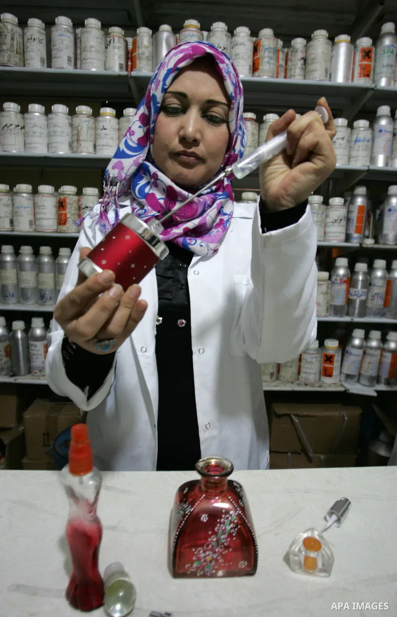 A Palestinian women uses a syringe as she mixes a concoction in a small laboratory manufacturing perfumes to sell locally in the Rafah refugee camp in the southern Gaza Strip on January 8, 2012. A report released in Octo...