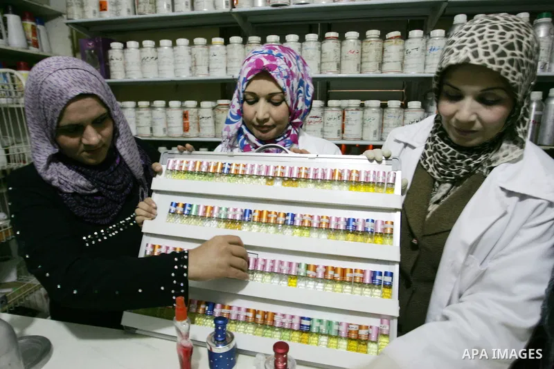 Palestinian women stand behind a counter in a small laboratory manufacturing perfumes to sell locally in the Rafah refugee camp in the southern Gaza Strip on January 8, 2012. A report released in October 2011 by the Worl...