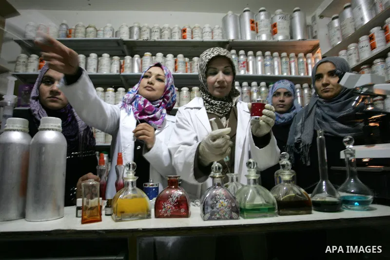 Palestinian women stand behind a counter in a small laboratory manufacturing perfumes to sell locally in the Rafah refugee camp in the southern Gaza Strip on January 8, 2012. A report released in October 2011 by the Worl...