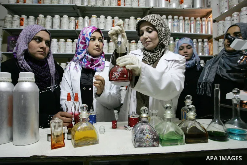Palestinian women stand behind a counter in a small laboratory manufacturing perfumes to sell locally in the Rafah refugee camp in the southern Gaza Strip on January 8, 2012. A report released in October 2011 by the Worl...