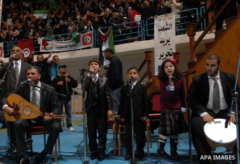 Supporters of the Tunisian islamist Ennahdha Party shout slogans and wave Palestinian flags during a speech delivered by Ismail Haniya, prime minister in the Hamas-ruled Gaza Strip, on January 8, 2012 in Tunis. A visit b...