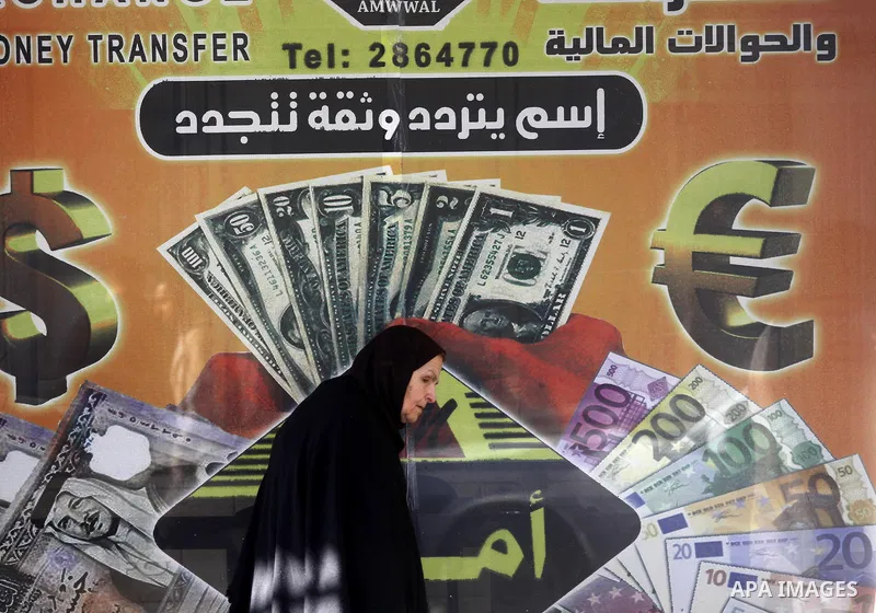 A Palestinian walks past a Western Union office in Gaza City Jan. 9, 2011. The Western Union, a global leader in money tranfer services based in the United States, decided on Tuesday to stop dealing with private offices...