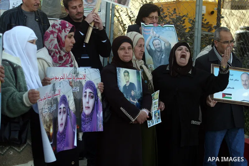 Palestinians hold up pictures of relatives held in Israeli jails during a protest calling for their release, in the West Bank city of Ramallah, on Jan. 10, 2012. Israel currently holds about 6600 Palestinians in its pris...