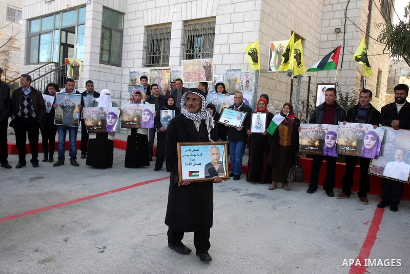 Palestinians hold up pictures of relatives held in Israeli jails during a protest calling for their release, in the West Bank city of Ramallah, on Jan. 10, 2012. Israel currently holds about 6600 Palestinians in its pris...