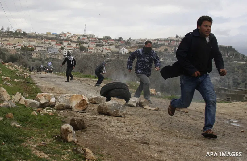 Palestinians run away from tear gas fired by Israeli security forces during a protest in the village of Kufr Qaddum near the Israeli settlement of Kdumim, in the northern West Bank, Friday , Jan. 13, 2012. Photo by Wagdi...
