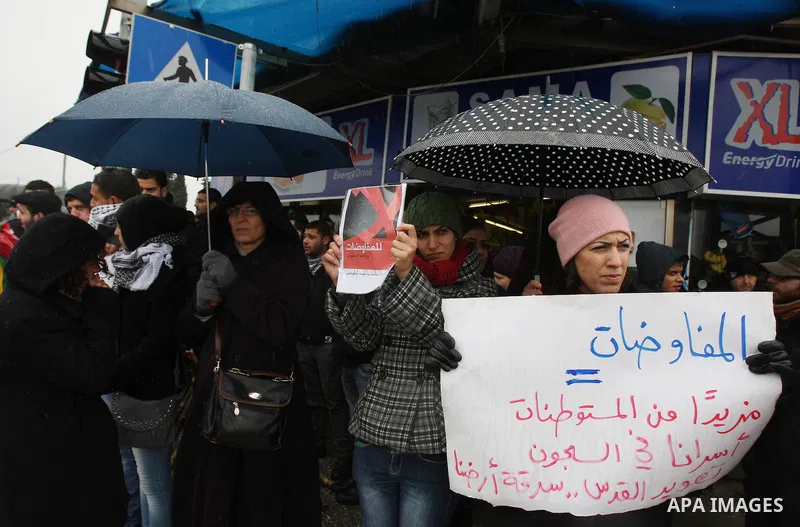 Palestinian activists hold banners during a protest the against peace talks in the West Bank city of Ramallah Saturday, Jan. 14, 2012. Palestinian and Israeli negotiators met last week for the first time in more than a y...