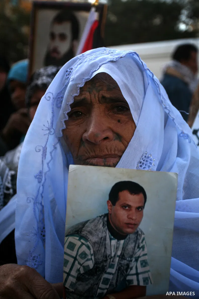 Palestinians woman hold pictures of their prisoned relatives in Israeli jails as they gather in a weekly activity calling for their liberty at the Red Cross headquarters in Gaza City on Jan. 16, 2012. Photo by Mahmoud Na...