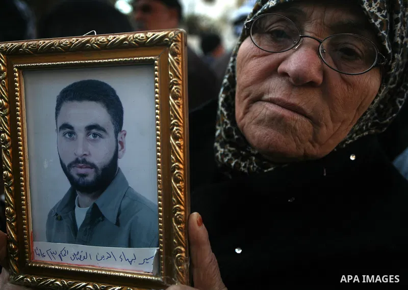 Palestinians woman hold pictures of their prisoned relatives in Israeli jails as they gather in a weekly activity calling for their liberty at the Red Cross headquarters in Gaza City on Jan. 16, 2012. Photo by Mahmoud Na...