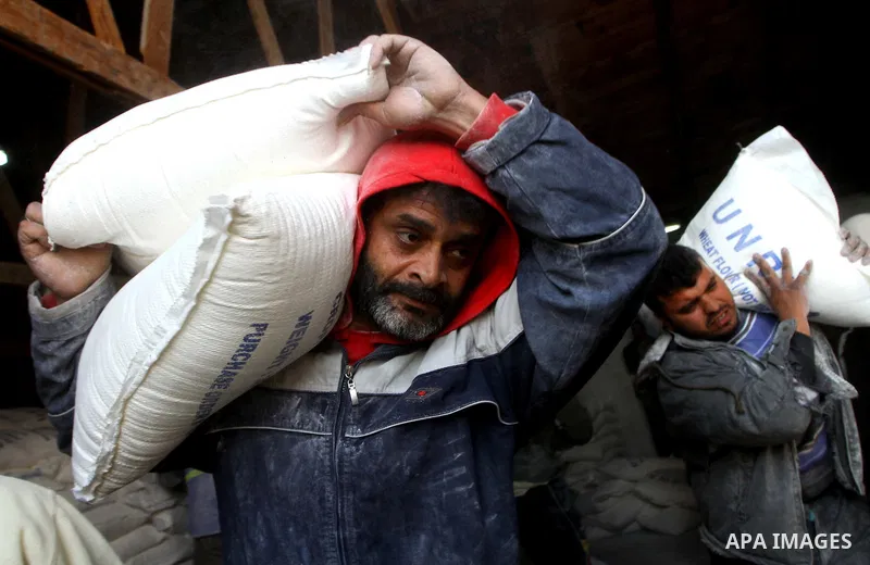 Palestinians receive their monthly food aid at a UN distribution center in the Shati refugee camp, in Gaza City, on January 17, 2012. The UN Agency for Palestinian Refugees (UNRWA) in Gaza launched an appeal for emergenc...