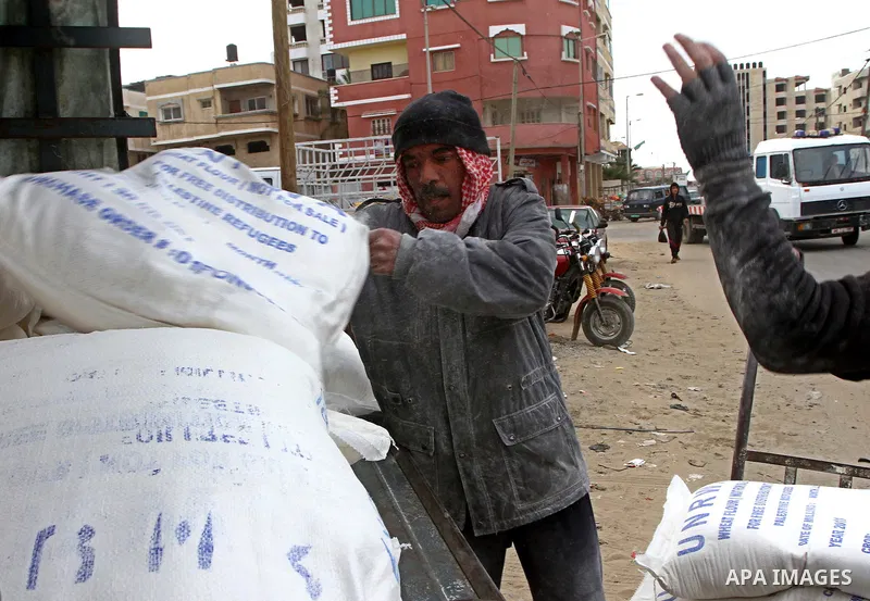 Palestinians receive their monthly food aid at a UN distribution center in the Shati refugee camp, in Gaza City, on January 17, 2012. The UN Agency for Palestinian Refugees (UNRWA) in Gaza launched an appeal for emergenc...