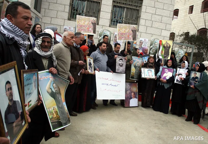 Palestinians hold portraits of relatives, held in Israeli jails, during a protest calling for their release, in the West Bank city of Ramallah, Tuesday, Jan. 17, 2012. Israel currently holds about 6,000 Palestinians in i...