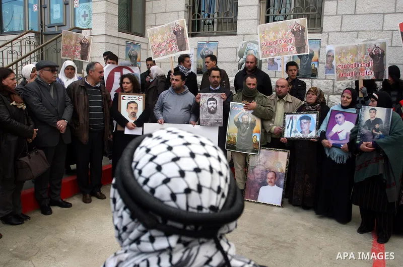 Palestinians hold portraits of relatives, held in Israeli jails, during a protest calling for their release, in the West Bank city of Ramallah, Tuesday, Jan. 17, 2012. Israel currently holds about 6,000 Palestinians in i...