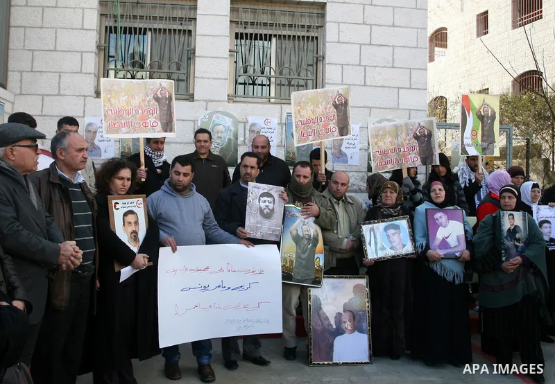 Palestinians hold portraits of relatives, held in Israeli jails, during a protest calling for their release, in the West Bank city of Ramallah, Tuesday, Jan. 17, 2012. Israel currently holds about 6,000 Palestinians in i...