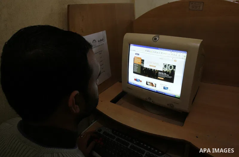 Palestinian man uses a computer as he looks at Visa cards on the web site in the southern Gaza Strip on January 18, 2012. The attacks were launched against Israeli sites at the beginning of this month when a Saudi intern...
