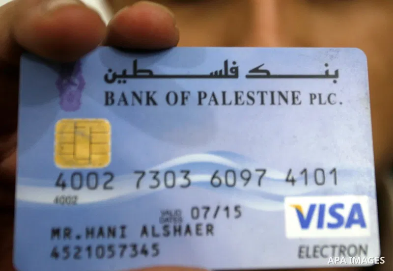 Palestinian man holds his Visa card in the southern Gaza Strip on January 18, 2012. The attacks were launched against Israeli sites at the beginning of this month when a Saudi internet expert called (0xomar) published de...