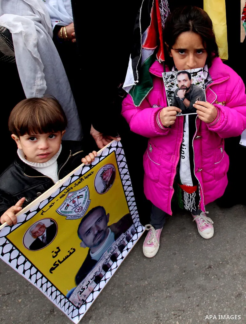Palestinian women and children hold pictures of their prisoned relatives in Israeli jails as they gather in a protest calling for their liberty at the Red Cross headquarters in Gaza City on Jan. 19, 2012. Photo by Ashraf...