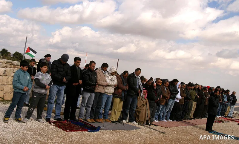 Palestinian demonstrators pray in the East Jerusalem neighbourhood of Issawiya on January 20, 2012 in protest against a decision by the Jerusalem municipality and Israel's Nature and Parks Authority (NPA) to build a nati...