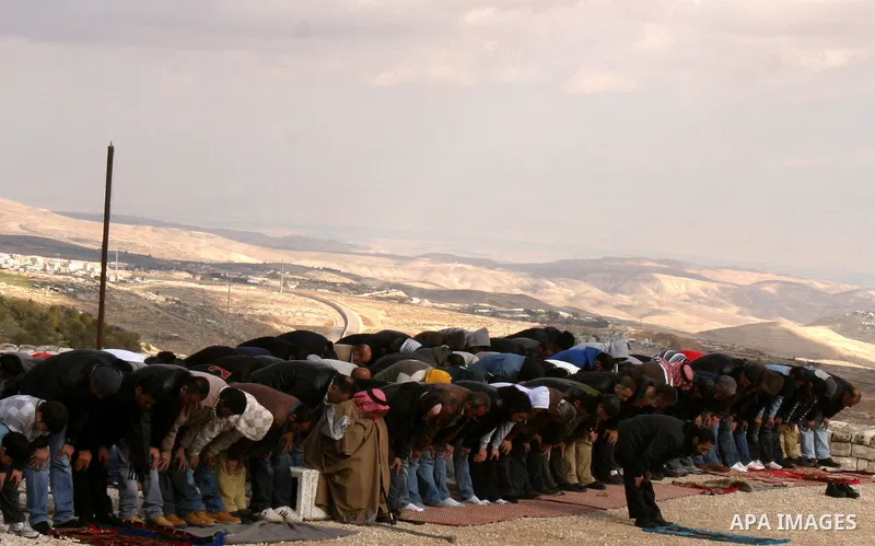 Palestinian demonstrators pray in the East Jerusalem neighbourhood of Issawiya on January 20, 2012 in protest against a decision by the Jerusalem municipality and Israel's Nature and Parks Authority (NPA) to build a nati...