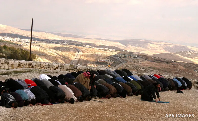 Palestinian demonstrators pray in the East Jerusalem neighbourhood of Issawiya on January 20, 2012 in protest against a decision by the Jerusalem municipality and Israel's Nature and Parks Authority (NPA) to build a nati...