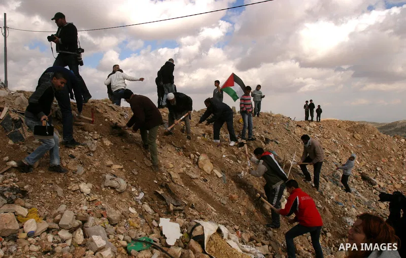 Israeli, Palestinian and foreign activists reopen a blocked road during a protest in the East Jerusalem neighbourhood of Issawiya on January 20, 2012 against a decision by the Jerusalem municipality and Israel's Nature a...