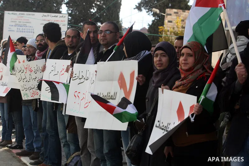 People hold Palestinian flags and placards during a protest against the peace negotiation talks between Palestinians and Israeli in front of Palestinian President Mahmoud Abbas's office in Ramallah, January 21, 2012. The...