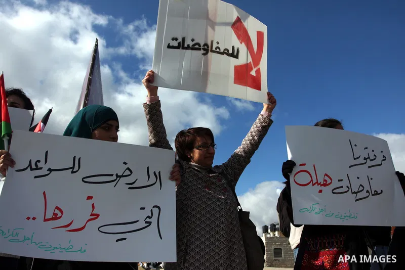 People hold Palestinian flags and placards during a protest against the peace negotiation talks between Palestinians and Israeli in front of Palestinian President Mahmoud Abbas's office in Ramallah, January 21, 2012. The...
