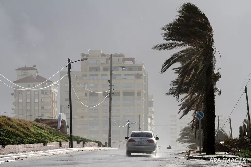 A car is driven through a road during heavy rains and winds in Gaza city on Jan. 22,2012. Photo by Mohammed Asad