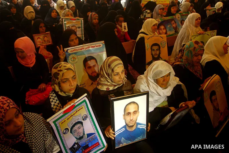 Palestinians man hold pictures of their prisoned relatives in Israeli jails as they gather in a weekly activity calling for their liberty at the Red Cross headquarters in Gaza City, on Jan. 23, 2012. Photo by Ashraf Amra
